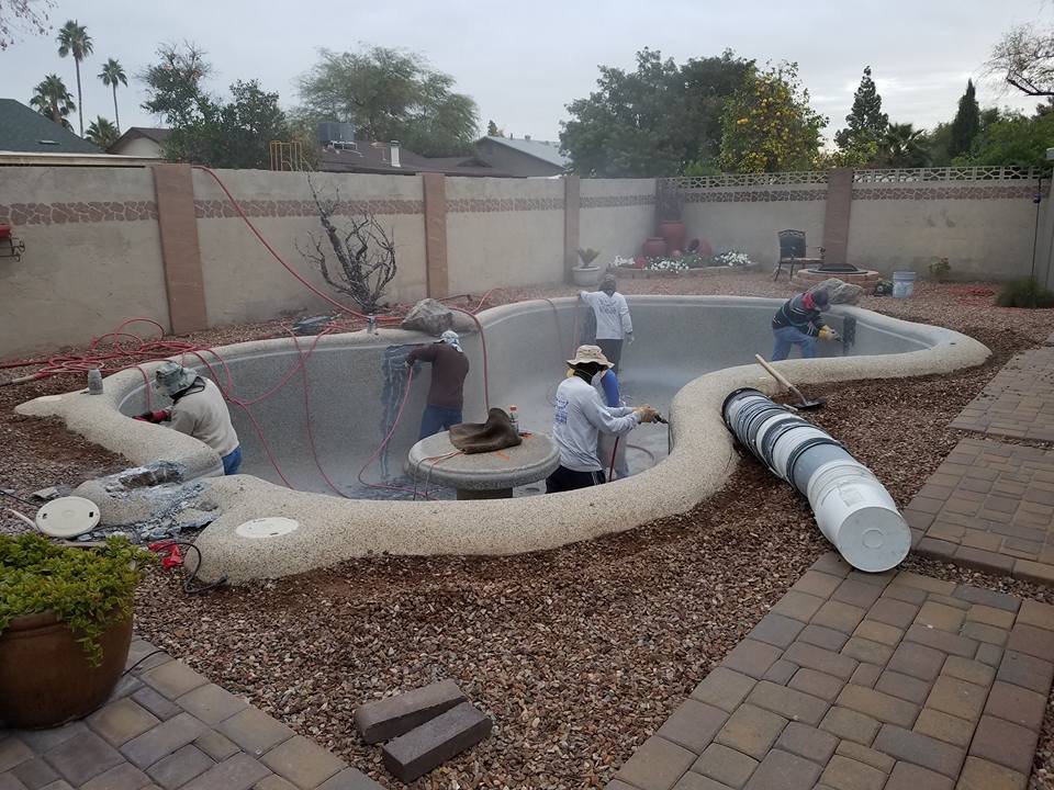 Pool professionals resurfacing a swimming pool